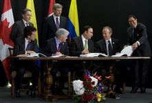[Prime Minister Stephen Harper and Colombian President Álvaro Uribe Velez oversee the signing of a free trade agreement between their countries while in Lima, Peru] 21 November 2008