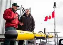 [Prime Minister Stephen Harper watches as Ryan Harris, Parks Canada, gives a scientific equipment demo aboard the HMCS Kingston as part of the 2014 Search for Franklin Expedition along the Northwest Passage] 24 August 2014