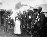 Poste d'évacuation sanitaire. Des blessés canadiens présentent à une infirmière un chien qu'ils ont ramené des tranchées. Octobre 1916 Octobre 1916.