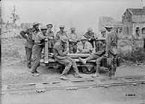 Canadian stretcher bearers playing a game of poker on Railway truck in Lens. September, 1917 Sep., 1917.
