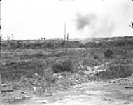 Canadians advancing in the distance. Shell bursting in foreground. Advance East of Arras. August, 1918 August, 1918.
