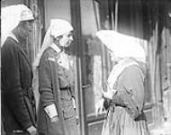 Canadian Sisters talking to a French Nun, who cared for our wounded in Valenciennes. November, 1918 Nov., 1918.