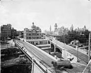 Parliament Buildings, Post Office and surroundings as seen from the Eastern junction of the Sappers' and Dufferin Bridges. [between 1890-1895].