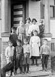Maliseet (Wulustukwiak) First Nation students on the steps of Woodstock Indian Day School, New Brunswick. [The boy sitting on the far right has been identified as Dr. Peter Lewis Paul, 1902-1989.] n.d.