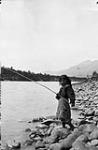 A Gitxsan First Nation girl fishing in the Skeena River at Kitwanga (Gitwangak/Gitwangax), British Columbia 1915.