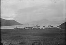 (Canada Alaska Boundary) "Dutch Harbour, Unalaska Island - H.M.S. "Pheasant" at anchor in the Bay; Str. "Humbolt" at Wharf and Str. "Excelsior" alongside, 1895."