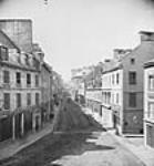 Looking along St. John Street to St. John Gate, from Couillard St [between 1868-1871].