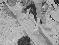 W.A. Beamish prepares sluice at Stout's gulch near Barkerville, B.C 1938