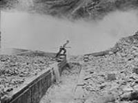 Monitors in Action: - Pronger jumps 6 ft. wide flume at Bullion as a "double" swings into mouth of wing dam, Quesnel River, B.C 1938
