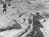 W.A. Beamish about to release the water into sluice box near Barkerville, B.C 1938