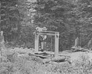 Small shaft prospect, view showing prospector using bucket, 1 mile North West of Barkerville, B.C 1938