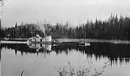 Sternwheeler with ore barge on Schist Lake, Man