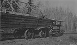 Best 75 h.p. gas tractor owned by the Alberta & Arctic transportation Co. hauling scow used by G.H. Blanchet, D.L.S. over 16 mile portage road between Fitzgerald and Smith, N.W.T