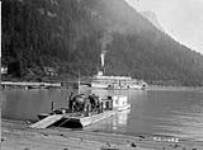 pack horses on scow at Arrowhead, B.C. Steamer in background is C.P.R. (Canadian Pacific Railway) boat "Bennington". 1928