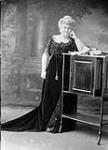 Lady Laurier (nee Zoe Lafontaine) standing beside Cabinet with roses Dec. 1911