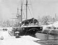 Snow scene showing stern of H.M.S. "Phaeton" in Esquimalt graving dock 1898