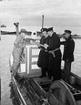 R.C.N. officer questioning Japanese Canadian fishermen while confiscating their boat 9 Dec. 1941