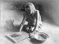 A [Hopi] potter mixing clay; [north east Arizona] 1922
