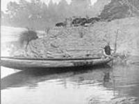A Hupa fishing from a canoe, [California]. Because of the dearth of redwood in their territory, the Hupa purchased all their canoes from the Yurok 1924