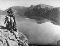 A Klamath Indian sitting on the shore of Crater Lake, in the heart of the Cascae Mountains of southern Oregon 1924