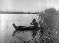 A (Lake Pomo) hunter on Clear Lake, (California), the abundant tule along the shallows of this lake supplied the natives with material for house coverings, mats, garmets, etc 1924