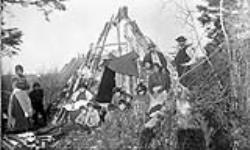 Group of Mi'kmaq in front of a wigwam at their camp in Elmsdale, Nova Scotia 1891