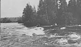 [Métis] men canoeing through rapids, Oxford House, Manitoba [c.a. 1910]