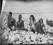 Four Inuit men sitting by the shore, Baker Lake (Qamanittuaq), Northwest Territories [Nunavut] 1893