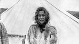 An Inuit girl standing outside a tent, Arctic Red River, N.W.T.
