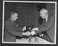 [The Induction of the late Alf Smith into the Hockey Hall of Fame, 1962. Norman Smith (left) accepts the award from Clarence Campbell.] 1962
