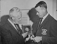 Gordie Howe receiving a medal from David Turner, member of Canada's Sports Hall ca. 1960's