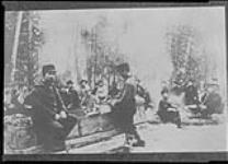 Work crew, including teacher from Frontier College, having dinner at work site c 1905