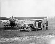 Auburn motor car with Travel Air 6000 aircraft at De Lesseps Aerodrome 13 June 1929