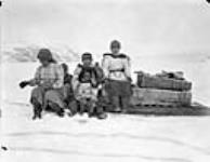 Inuit sitting on a [Qamutik] Komatik, (sled), Wakeham Bay, Quebec [Nunavut], 1928 1928.
