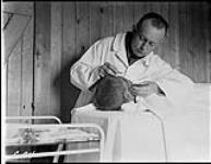 (Hudson Strait Expedition). Dr. W.J.K. Clothier performing an operation at Base 'C' 1928