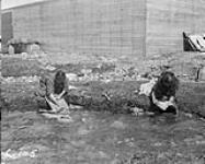 Inuit woman doing washing by the waterfront 1928.