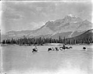 Fording the Howse River at the junction of the North Saskatchewan River, with Mount Murchison in the background, Banff National Park, [Alta.], Oct. 1927