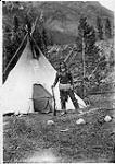 [First Nation man, Sitting Eagle - John Hunter] [Indian with rifle, in front of teepee, Banff National Park, Alta.] [1902]