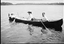 Two women with a man in a canoe on Mississippi Lake n.d.