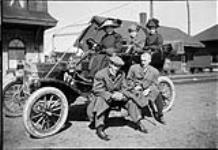 Group posing with 1908 or 1909 Ford automobile taken at the former Grand Trunk Railway, and later Canadian National Railways Station [graphic material] ca. 1908 - 1909