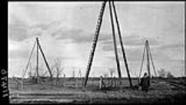 Simpson standing by oil derricks in Petrolia 17 Nov. 1914