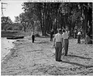 Men playing horseshoes at a picnic, possibly a post-office picnic c.a. 1952