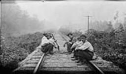 Men fighting bush fire, sitting on [railway] tracks Aug. 1916