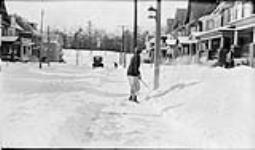 Edna [Boyd] cleaning snow from the sidewalk 22 Jan., 1917