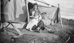 [Liza and baby Rish, members of the Tlicho (formerly Dogrib) First Nation, at a camp in an unidentified location, Northwest Territories, 1937.] Original Title: Liza & Rish (Dogrib Indians) 1937