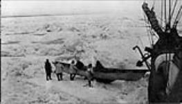 Taking a skin boat or "umiak" aboard the H.M.C.S. KARLUK. With ice conditions they were compelled to back their way through the ice 1913