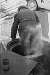 Man emerging from manhole, Feb. 21, 1955. Possibly the man who resided in manhole in Toronto 21 Feb. 1955