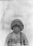 Young Inuit boy in front of a cloth backdrop August 1927.