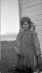 Inuit girl carrying child. [Ataguttak carrying baby Kalluk in a women's "amauti".] Aug. 1923