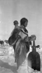 [Netselingment Inuk woman with a baby holding a snow shovel] Original title: Netselingment woman with native snow shovel April 1926.